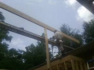 Carpenter setting a ridge beam over a new addition frame — Ice Dam Removal by Roofing Brothers in White Earth