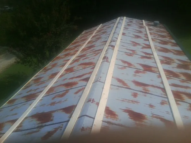 Rusted metal roof panels with new wood purlins before replacement — Storm Damage Roof Repair in White Earth by Roofing Brothers
